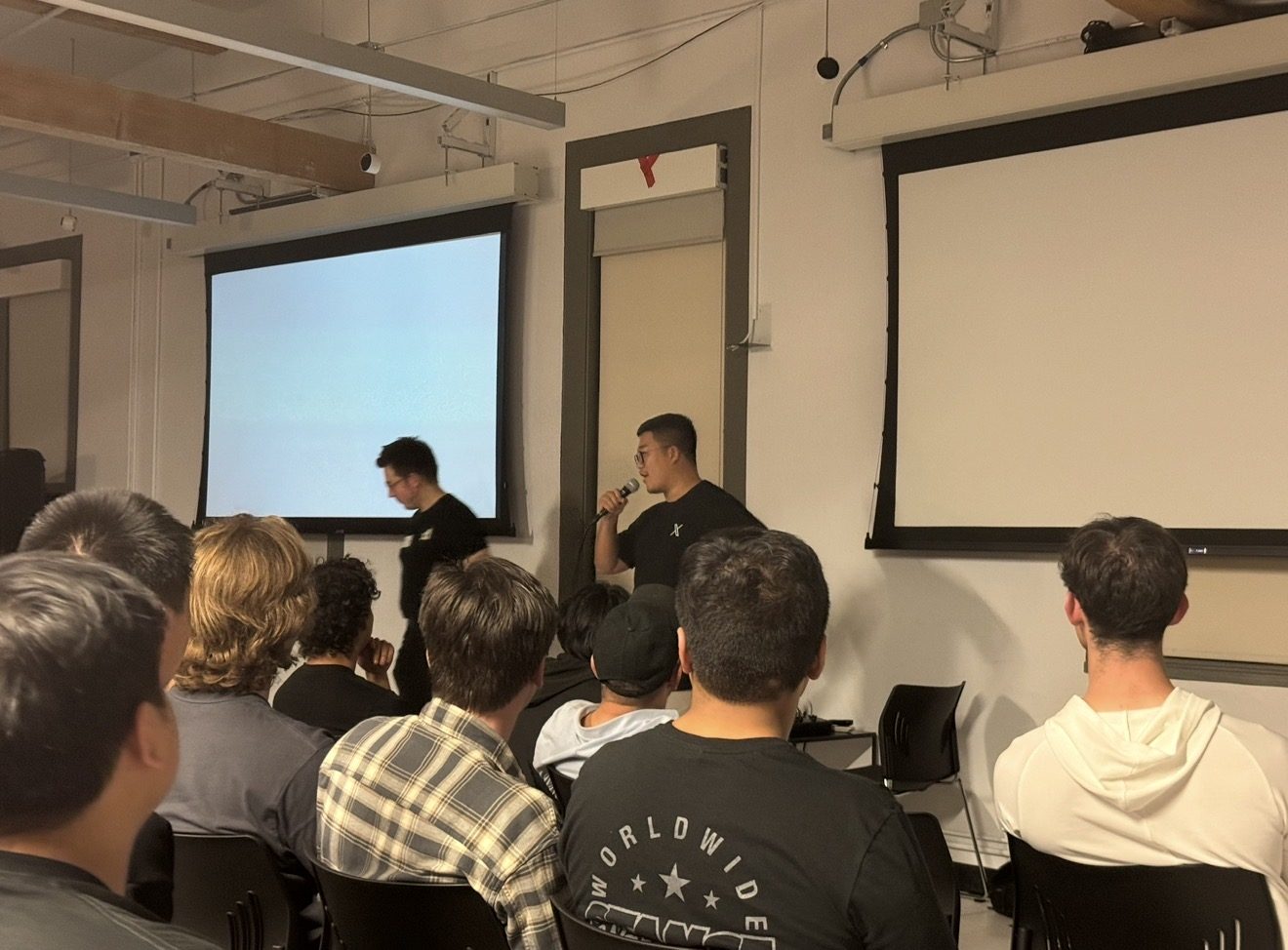 Christopher presenting on stage with xAI co-founder Igor Babuschkin
